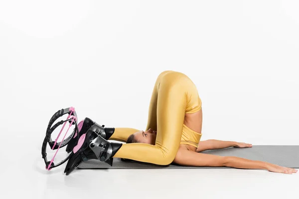 Flexible Frau in aktiver Kleidung Stretching Body auf Fitnessmatte, Kangoo Springschuhe, Motivation — Stockfoto