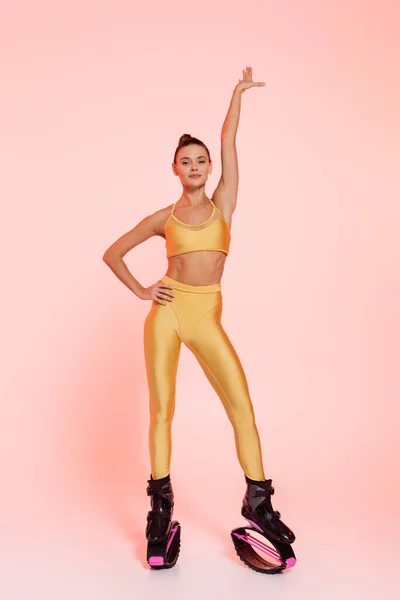 Mulher em sportswear e kangoo salto sapatos, fundo rosa, corpo tonificado, motivação e energia — Fotografia de Stock