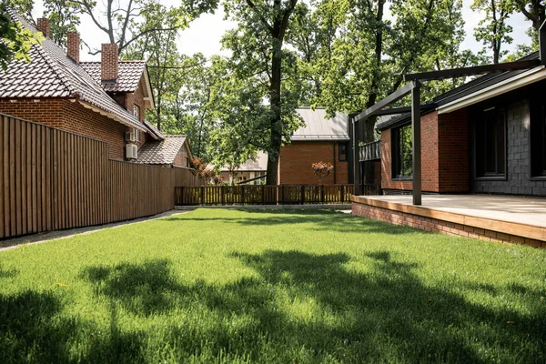 Maison moderne avec patio, pelouse verte, clôture en bois, ville chalet, marché immobilier — Photo de stock