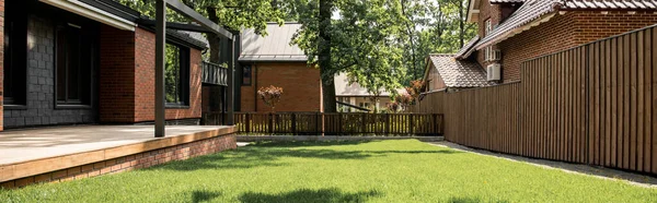 Maison confortable avec patio, pelouse verte, clôture en bois, ville chalet, marché immobilier, bannière — Photo de stock