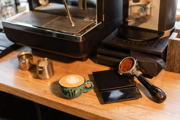 Café no suporte perto da xícara de cappuccino na oficina no café — Fotografia de Stock