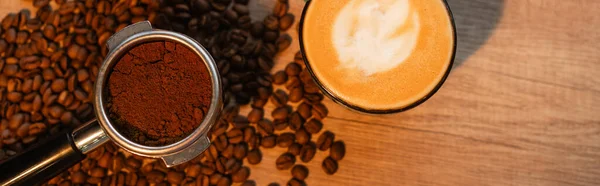 Draufsicht auf Halter mit Kaffee in der Nähe von Cappuccino auf Kaffeebohnen im Café, Banner — Stockfoto