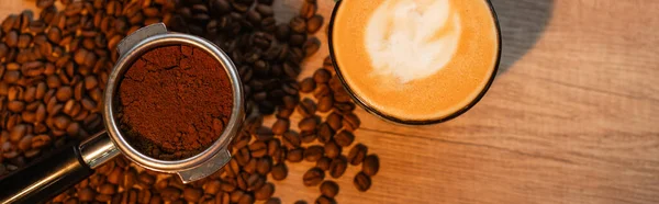 Top view of holder with coffee near cappuccino on coffee beans in cafe, banner — Stock Photo