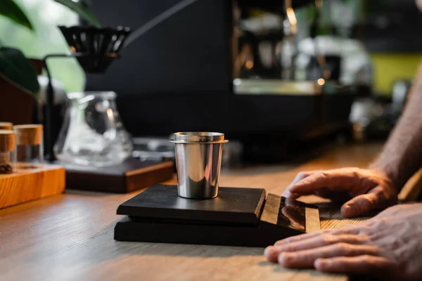Vue recadrée du barista debout près du bécher sur des balances électroniques près de la machine à café dans le café — Photo de stock