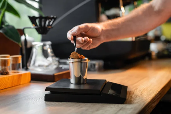 Vista cortada de barista derramando café em copo em balanças eletrônicas perto da máquina de café no café — Fotografia de Stock