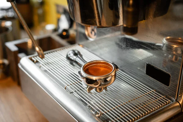 Primer plano vista del titular con café en la máquina de café en la cafetería - foto de stock