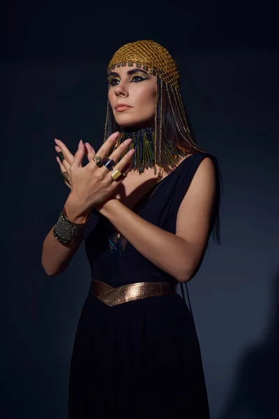 Mulher elegante em vestido egípcio e cobertura para a cabeça posando enquanto em pé no fundo azul — Fotografia de Stock