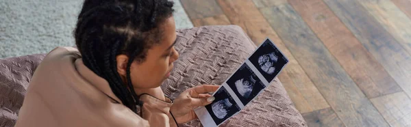 Top view of african american woman lying on bed, looking at ultrasound, abortion concept, banner — Stock Photo