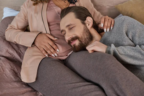 Future parents, happiness, bearded man listening belly of pregnant african american wife in bedroom — Stock Photo