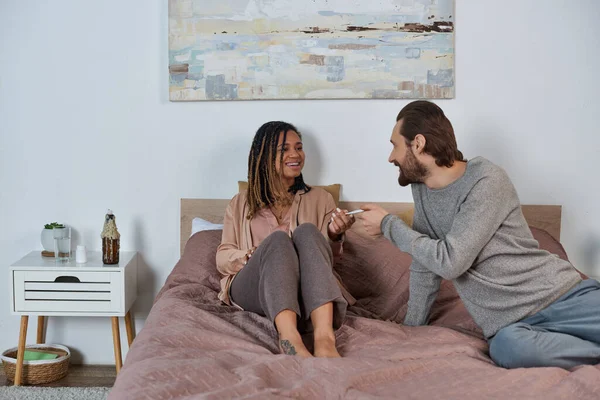 Bearded man passing pregnancy test to african american wife, future parents, expectation, sentiment — Stock Photo