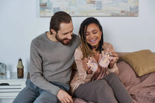 Щасливий чоловік проходить тест на вагітність для афроамериканської дружини, майбутніх батьків, очікування, почуття — стокове фото