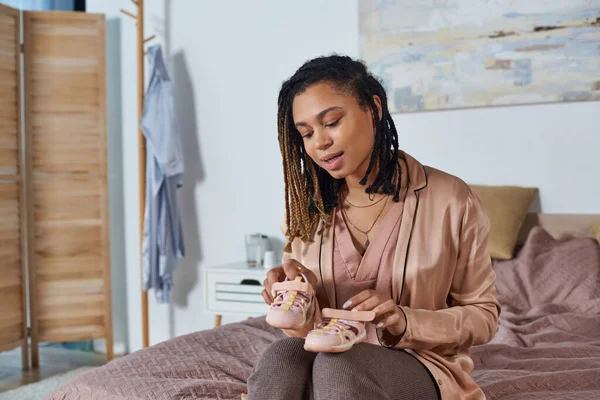 Excited african american woman holding tiny baby shoes, future mother, expectation, awaiting — Stock Photo