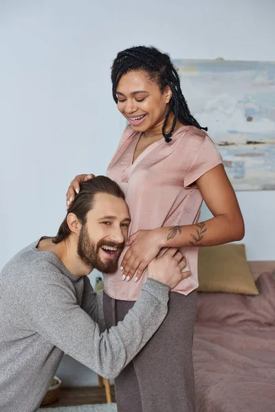 Homme heureux à l'écoute ventre de femme enceinte afro-américaine, fertilité, couple, futurs parents — Photo de stock