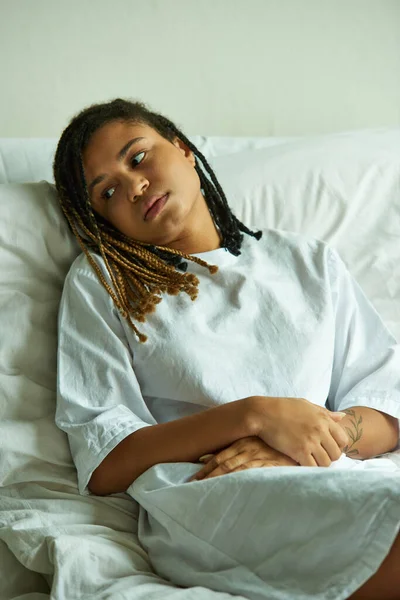 Dolore, donna afroamericana depressa sdraiata in reparto privato, ospedale, aborto spontaneo, tatuaggio — Foto stock