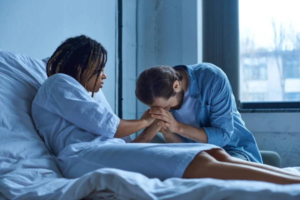 Fehlgeburt, depressive Afroamerikanerin hält Hand ihres trauernden Ehemannes, Krankenhausstation — Stockfoto