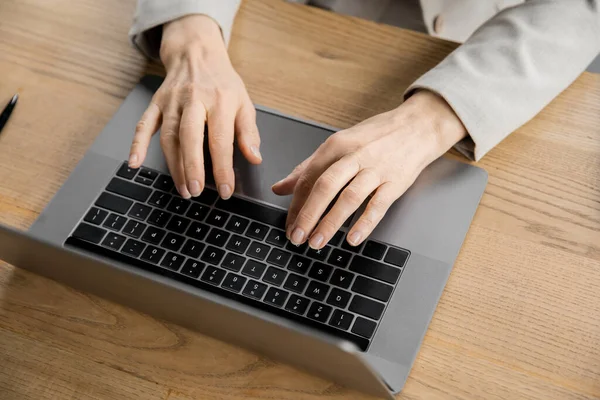 Abgeschnittene Ansicht einer Geschäftsfrau mittleren Alters, die auf einem Laptop im modernen Büro tippt, Draufsicht — Stockfoto