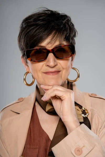 Moda queda, mulher madura elegante em óculos de sol, casaco de trincheira, cachecol e brinco em cinza — Fotografia de Stock