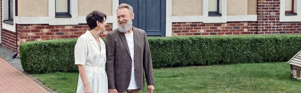 Allegra coppia anziana, uomo e donna in piedi vicino a casa e guardarsi, amore, striscione — Foto stock