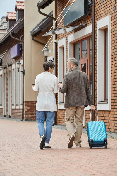 Casal de idosos, homem barbudo e mulher andando com café para ir e bagagem, estilo de vida urbano — Fotografia de Stock