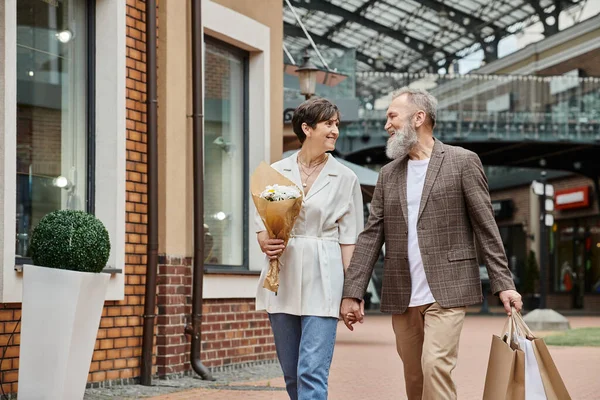 Glückliches älteres Paar beim Einkaufen, Blumen, älterer Mann und Frau Händchenhalten, alternde Bevölkerung — Stockfoto