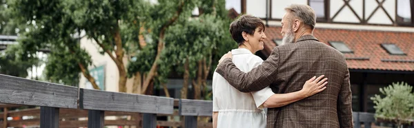 Feliz casal de idosos, homem e mulher abraçando e andando juntos ao ar livre, sênior, romance, bandeira — Fotografia de Stock