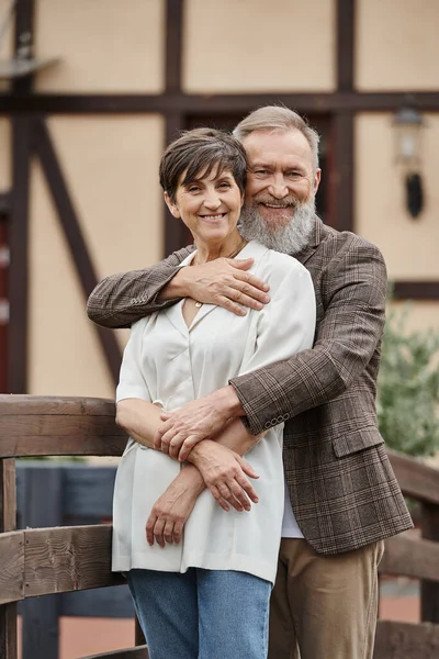 Bearded man hugging woman, husband and wife, senior romance, happy, aging population, outdoors — Stock Photo