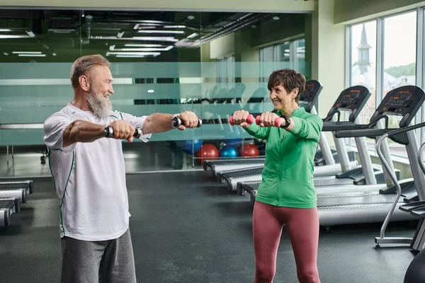 Pareja de ancianos, feliz hombre y mujer haciendo ejercicio con pesas, personas mayores activas, marido y mujer — Stock Photo