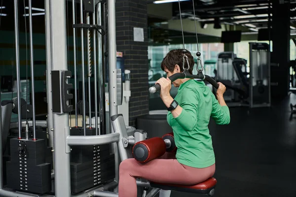 Femme âgée forte et motivée travaillant dans la salle de gym, fitness mature, machine d'exercice, active — Photo de stock