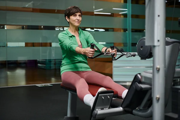 Forte et motivée, femme âgée travaillant dans la salle de gym, fitness, machine d'exercice, sportive — Stock Photo
