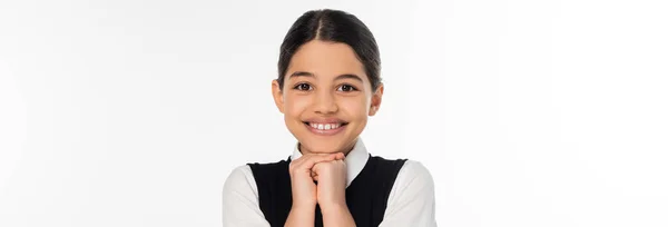 Щаслива школярка в чорному жилеті дивиться на камеру ізольовано на білому, шкільна форма, збуджена, банер — стокове фото