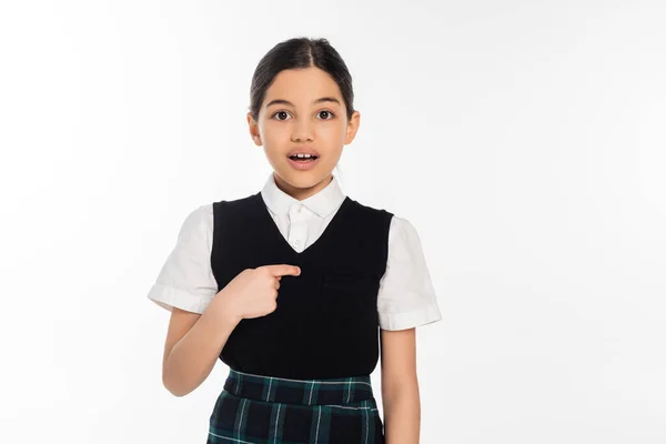 Überrascht Schulmädchen zeigt mit dem Finger auf sich selbst und schaut in die Kamera isoliert auf weiß, Mädchen — Stockfoto