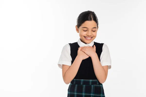 Heureux écolière souriant avec les yeux fermés isolé sur blanc, flatté, émotion, uniforme scolaire — Photo de stock