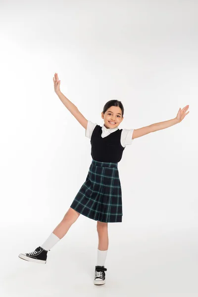 Excited schoolgirl standing with outstretched hands isolated on white, full length, happiness — Stock Photo