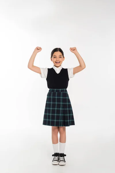 Emoção, colegial feliz comemorando de volta à escola, isolado em branco, comprimento total, uniforme — Fotografia de Stock