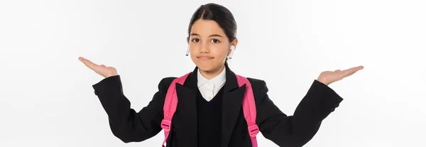 Écolière en uniforme avec écouteurs sans fil isolés sur blanc, pointant avec les mains, bannière — Photo de stock