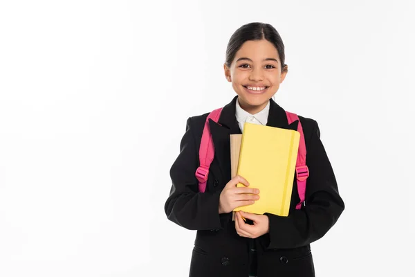 Happy schoolgirl looking at camera and holding notebooks isolated on white, student, back to school — Stock Photo