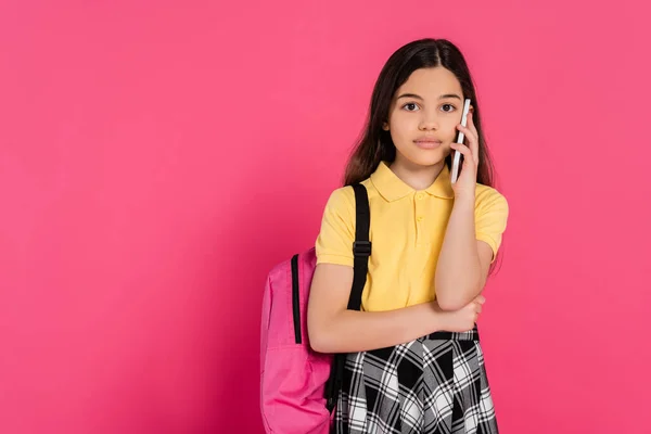 Llamada telefónica, chica morena utilizando teléfono inteligente aislado en rosa, fondo vibrante, positivo - foto de stock