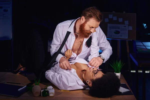 Bearded businessman undressing happy african american secretary on work desk, love affair in office — Stock Photo