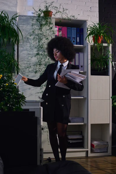 Donna afroamericana in elegante abbigliamento formale copiare documenti mentre si lavora di notte in ufficio — Foto stock