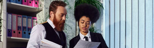 Young african american secretary and bearded businessman looking at documents in office, banner — Stock Photo