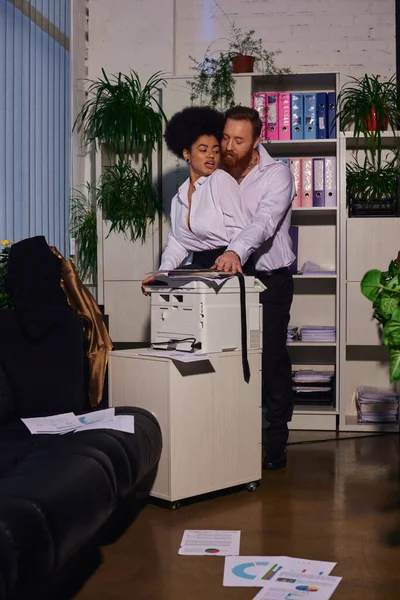 Relations sexuelles au bureau, homme d'affaires barbu séduire secrétaire afro-américain près copieur — Photo de stock