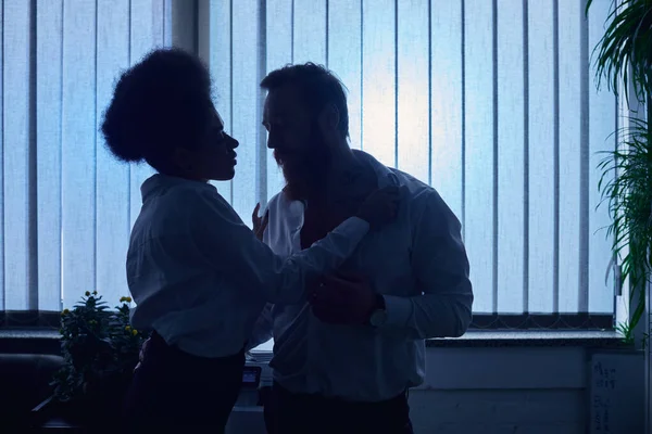 Love in night office, dark silhouette of passionate african american woman flirting with colleague — Stock Photo