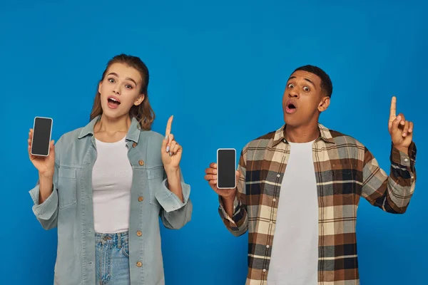 Donna allegra e felice afro americano con smartphone e puntando su sfondo blu — Foto stock