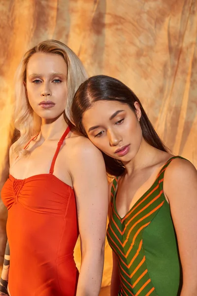 Sensual multiethnic models in swimwear posing on beige backdrop with drapery, diversity and fashion — Stock Photo