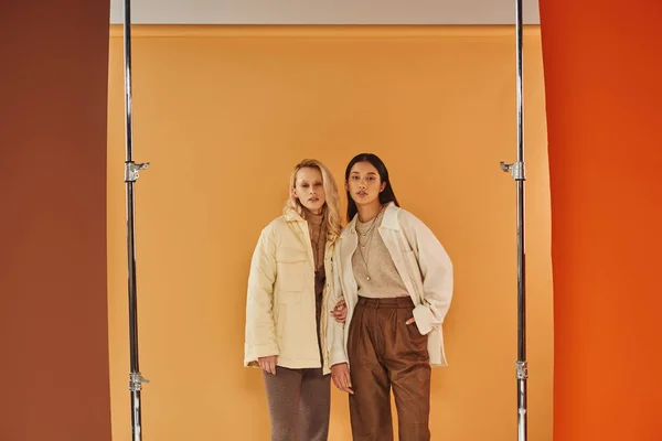 Fall fashion, young multiethnic women in stylish attire posing on pastel multicolored backdrop — Stock Photo