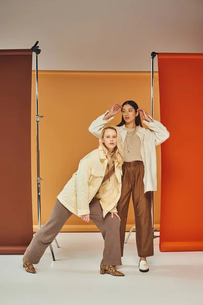 Herbstmode, junge und stylische Frauen in Herbstkleidung posieren vor buntem Hintergrund, Vielfalt — Stockfoto