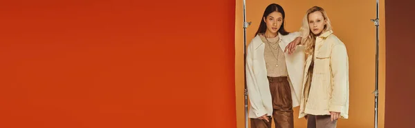 Herbstmode, interrassische Models in Herbstkleidung posieren vor pastellfarbenem Hintergrund, Banner — Stockfoto