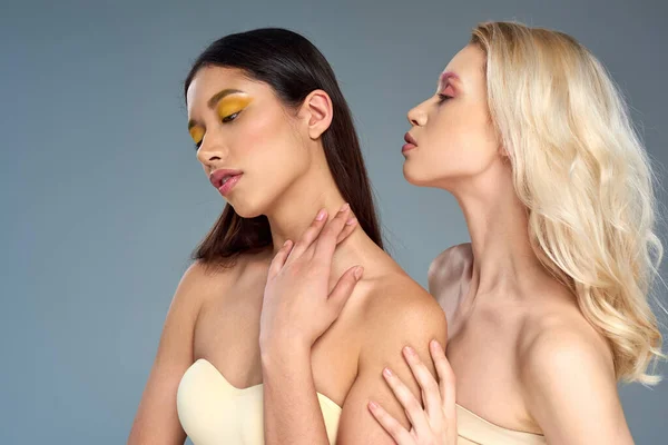 Diverse junge Models mit lebendigem Augen-Make-up posieren gemeinsam vor blauem Hintergrund, Beauty-Trend-Konzept — Stockfoto