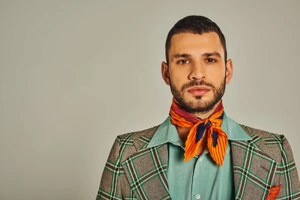 Portrait of serious man in plaid blazer and colorful neckerchief on grey, retro-inspired fashion — Stock Photo