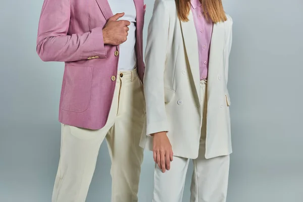 Cropped view of young business couple in elegant suits standing on grey backdrop, classic fashion — Stock Photo